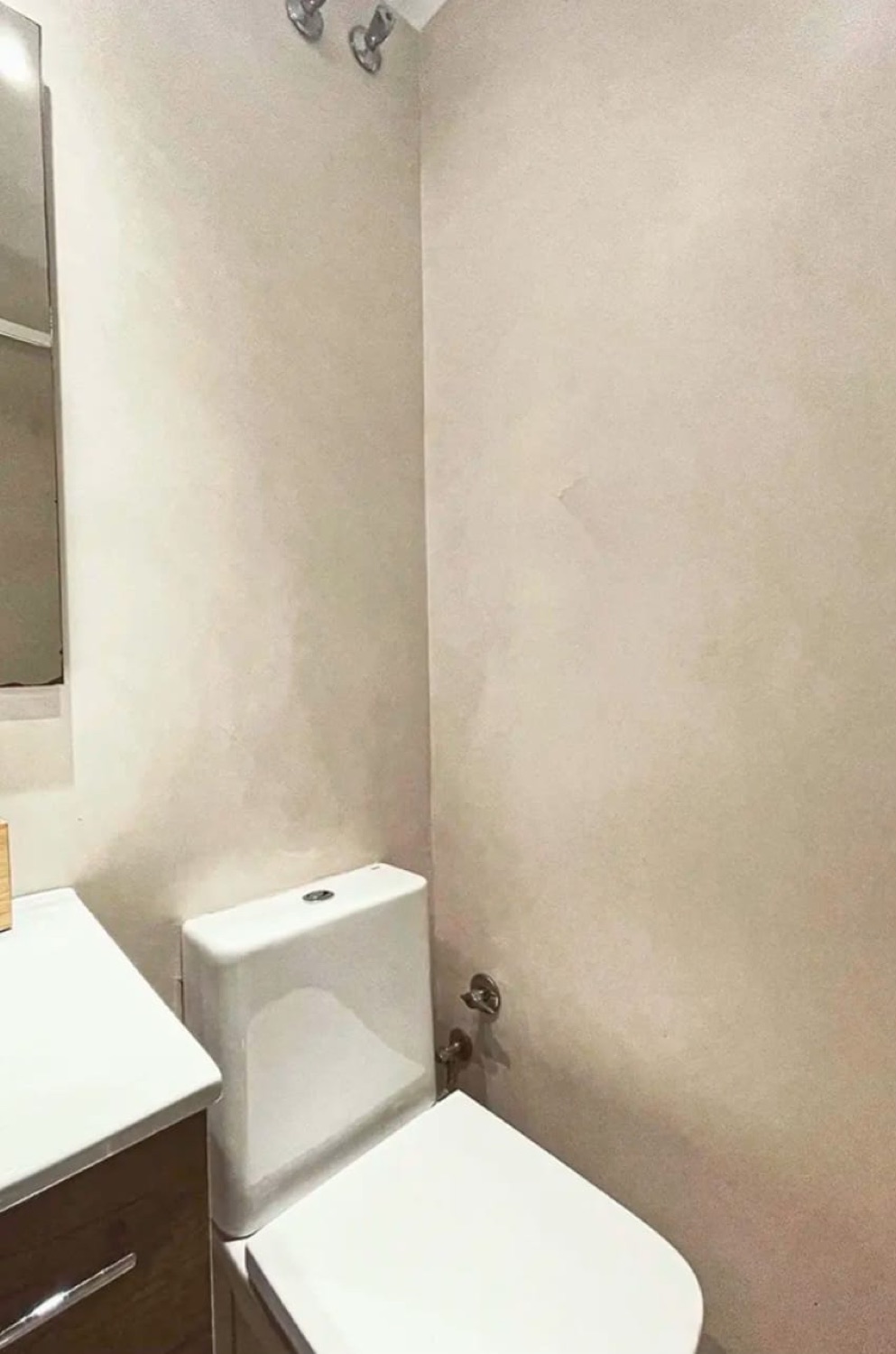 Aseo en microcemento beige con inodoro y lavabo