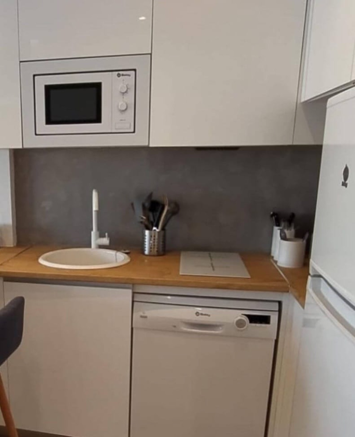 Cocina blanca con frente de microcemento gris y fregadero