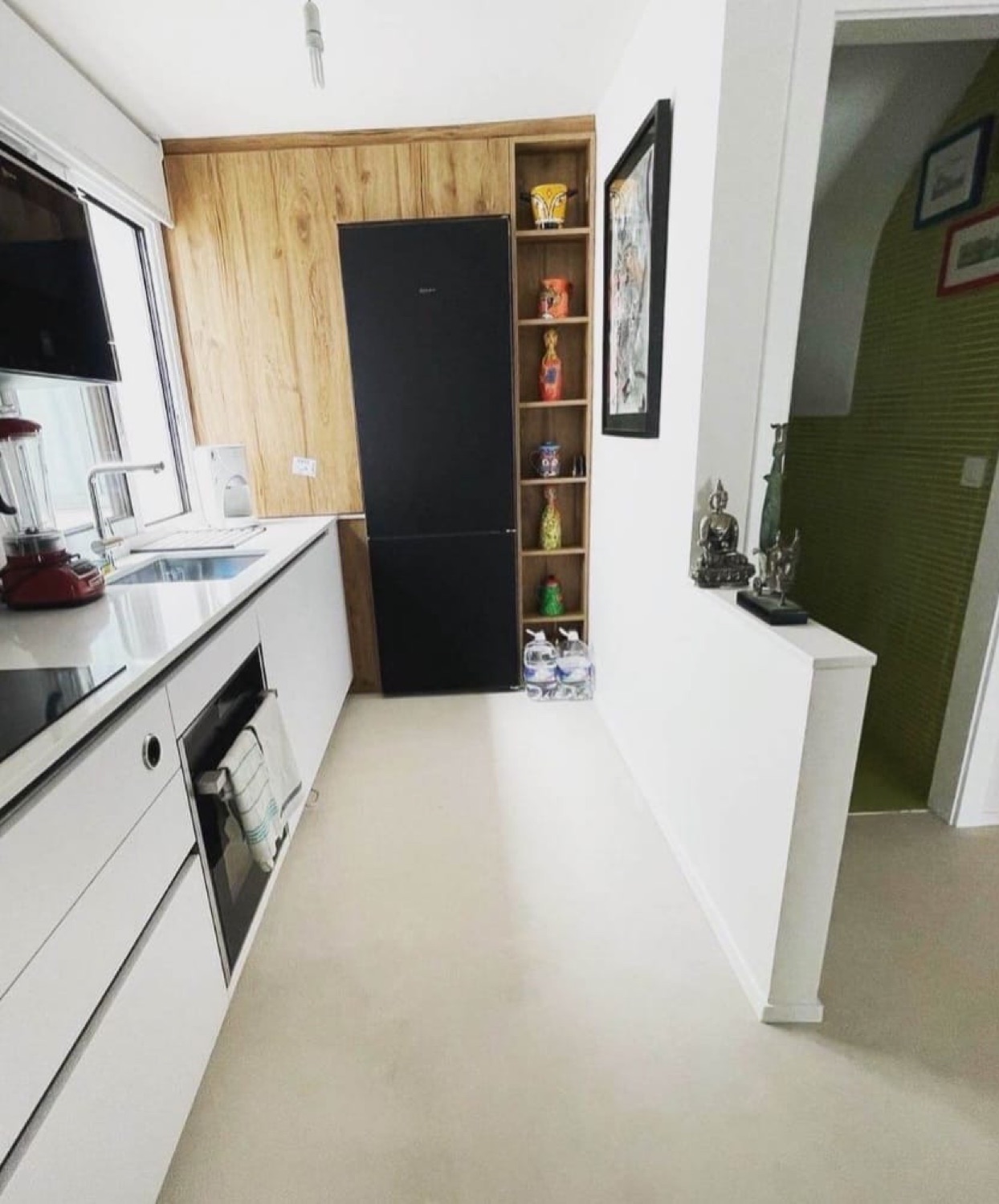 Cocina blanca con suelo de microcemento y estantería