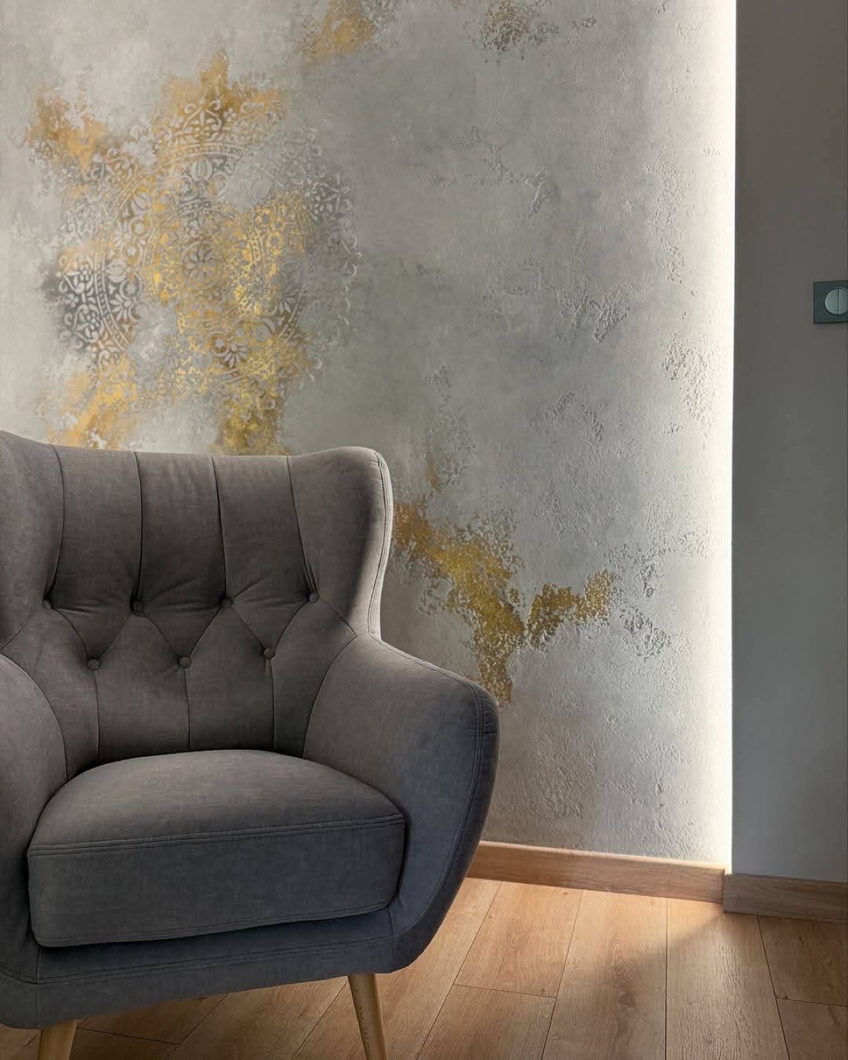 Pared de microcemento gris con mandala dorado