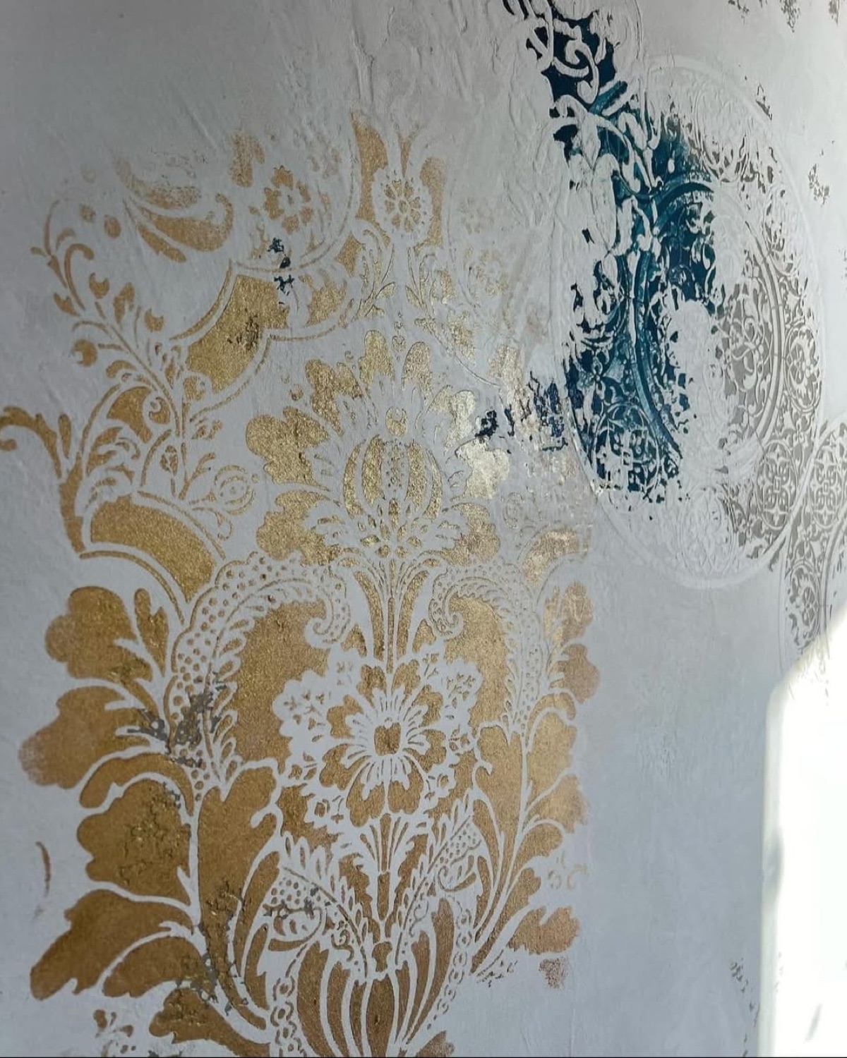 Pared blanca con estarcido dorado y azul