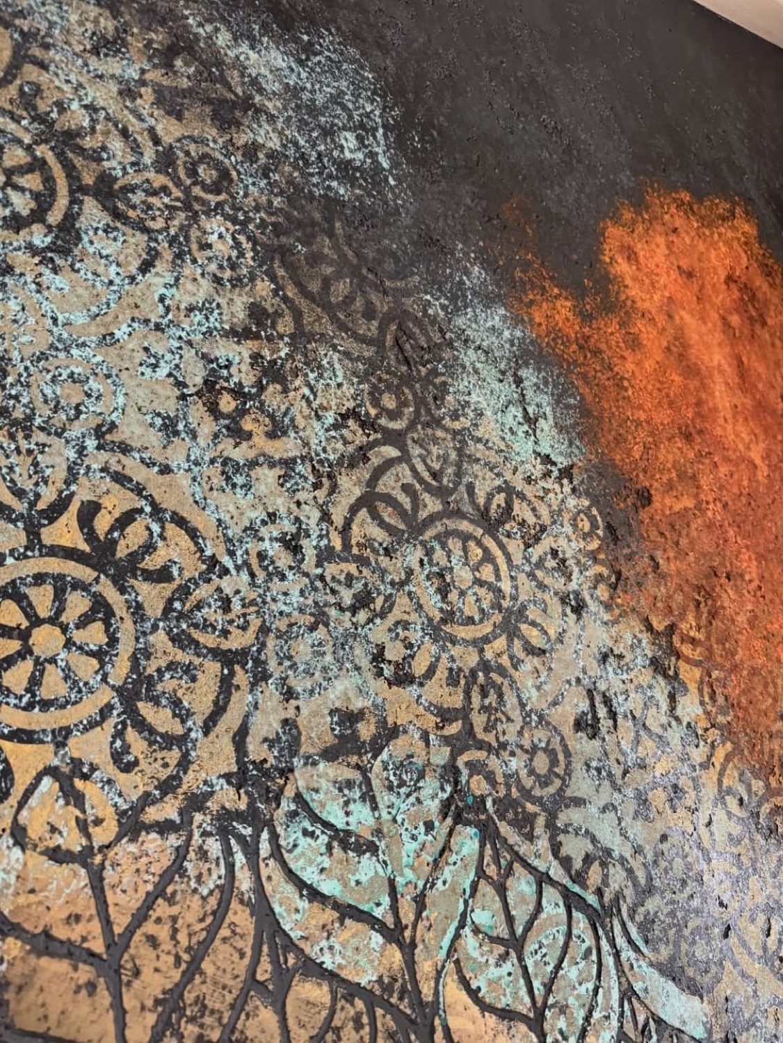 Detalle de mandala en óxido verde y naranja